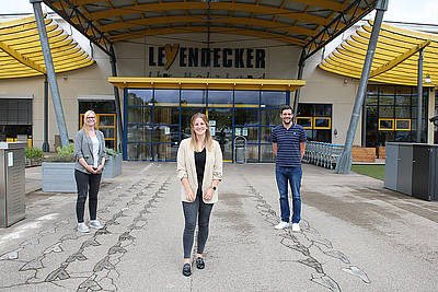 Auszubildende Anna Schmitt auf einem Foto mit Teamleiter Harald Emmrich und Ausbildungsleiterin Anke Kießling